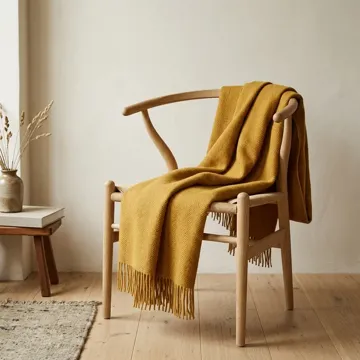 Eiken eetkamerstoel met een okergele plaid over de leuning
